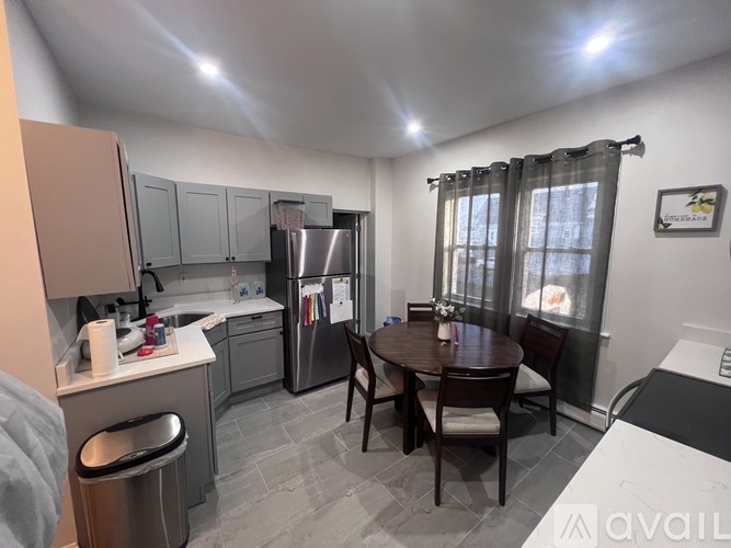 A kitchen with a table and chairs in front of a window.
