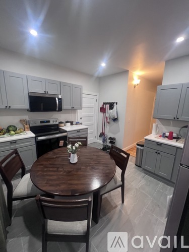 A kitchen with a table and chairs in the foreground.