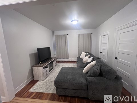 A living room with a grey couch and a television.