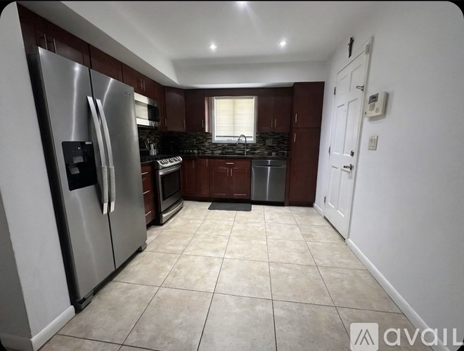 A kitchen with a refrigerator, oven, and microwave.