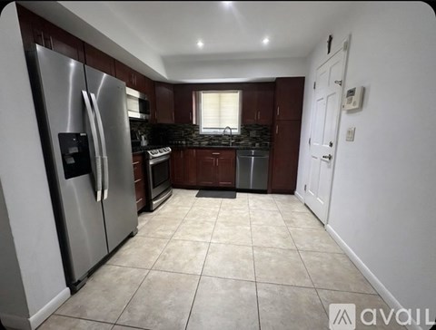 A kitchen with a refrigerator, oven, and microwave.