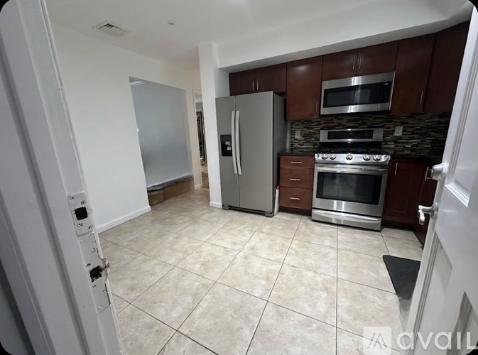 A kitchen with a refrigerator, oven, and microwave.