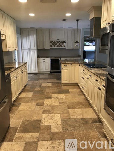 A kitchen with a checkered tile floor and white cabinets.
