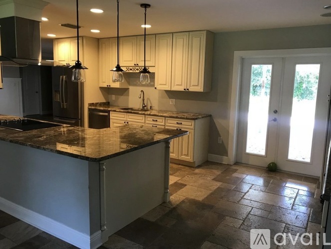A kitchen with granite countertops and a tile floor.