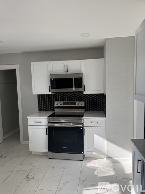 A modern kitchen with a stainless steel oven and microwave.