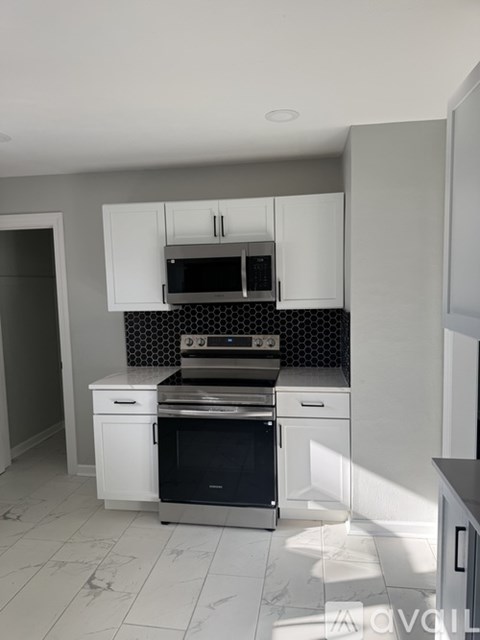 A modern kitchen with a stainless steel oven and microwave.