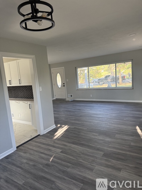 A room with a grey floor and a window showing a view of a street.