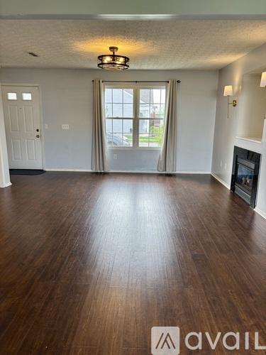 A room with wooden flooring and a fireplace.