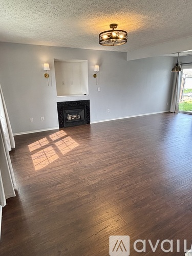 A living room with a fireplace and wood floors.