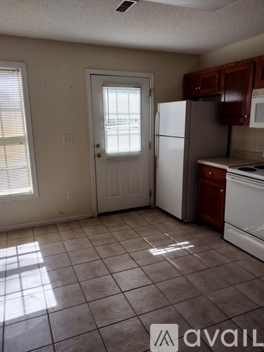 A kitchen with white appliances and brown cabinets.