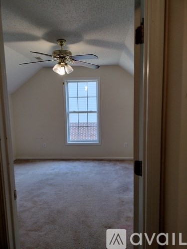 A room with a ceiling fan and a window.
