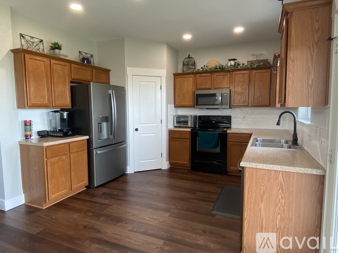 A kitchen with wooden cabinets and a black oven.