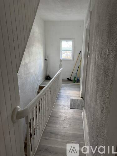A hallway with a window and a railing.