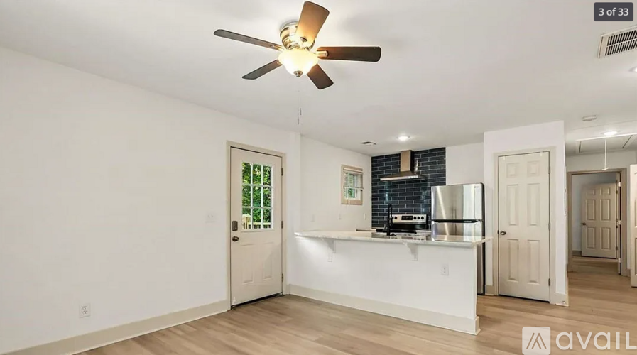 A room with a ceiling fan and a counter in it.