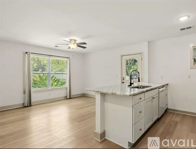 A kitchen with white cabinets and a marble countertop.