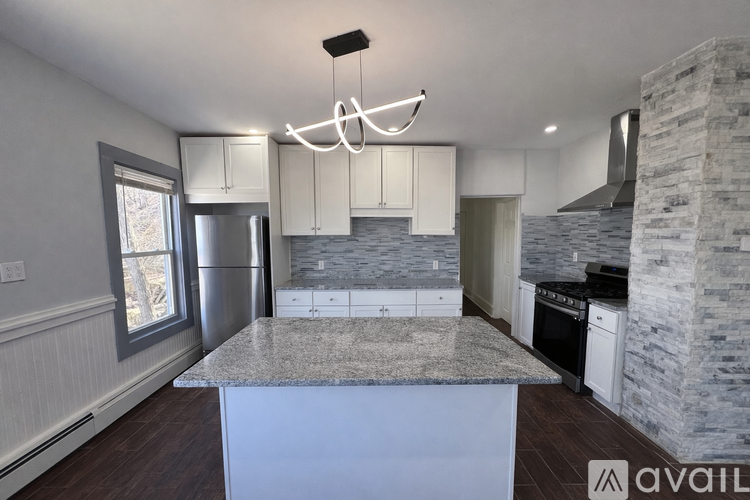 A kitchen with a marble island and a stone pillar.