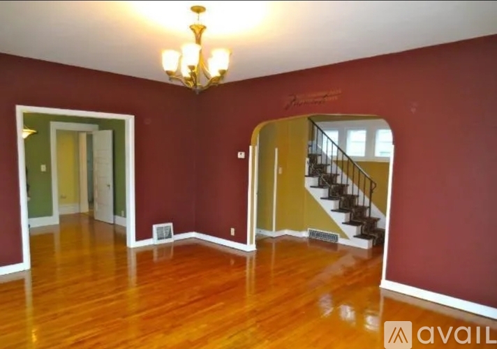 A room with a wooden floor and a staircase.
