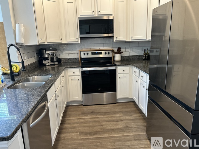 A kitchen with white cabinets and a black stove top oven.