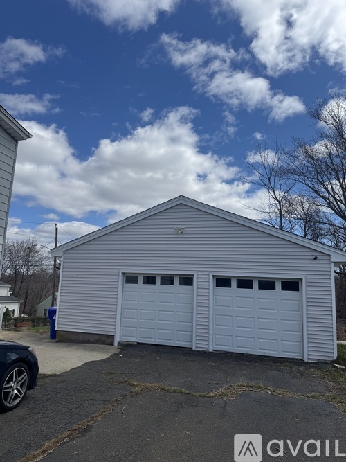 A two-car garage with a metal roof and a car parked in front.