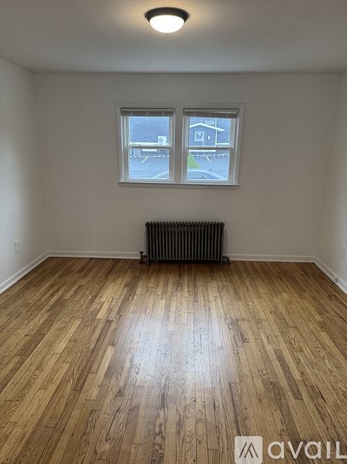A room with wooden flooring and a window.