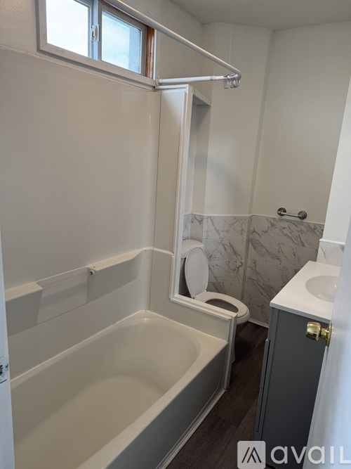 A bathroom with a white tub and a toilet.