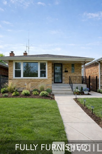 A house with a well-maintained lawn and a clear sky.