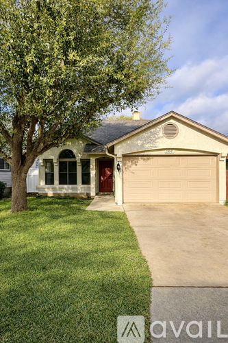 A house with a red door and a tree in front.