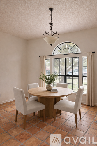 A dining room with a round table and chairs.