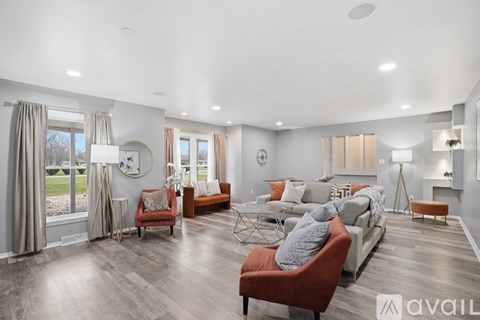 A living room with a red chair and a grey couch.