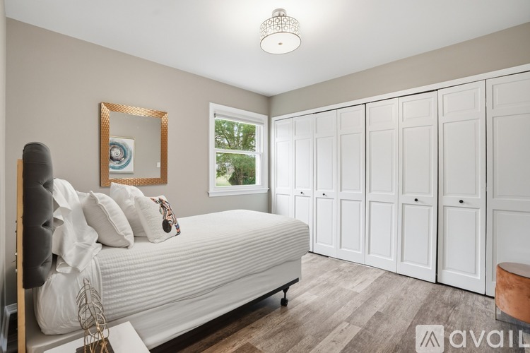 A bedroom with a large bed and a chandelier.
