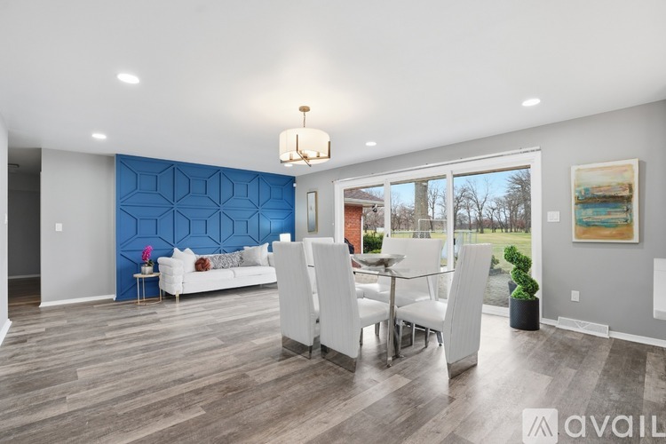 A modern dining room with a white table and chairs.