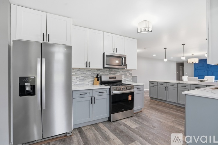 A modern kitchen with a stainless steel refrigerator and oven.