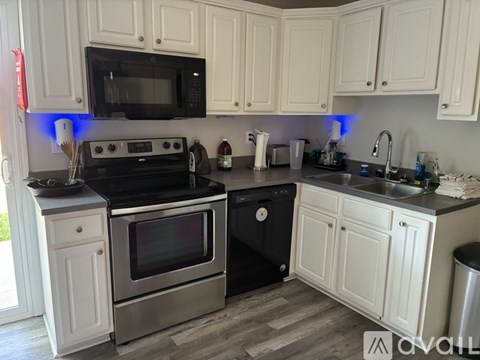 A kitchen with white cabinets and a black stove top oven.