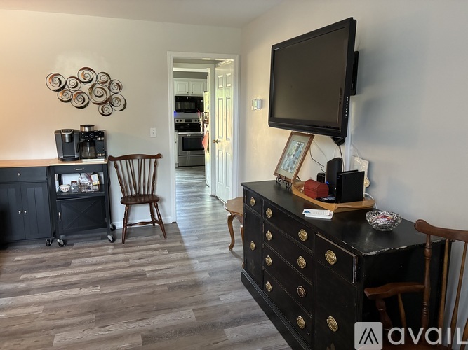 A black dresser with a flat screen TV on top of it.