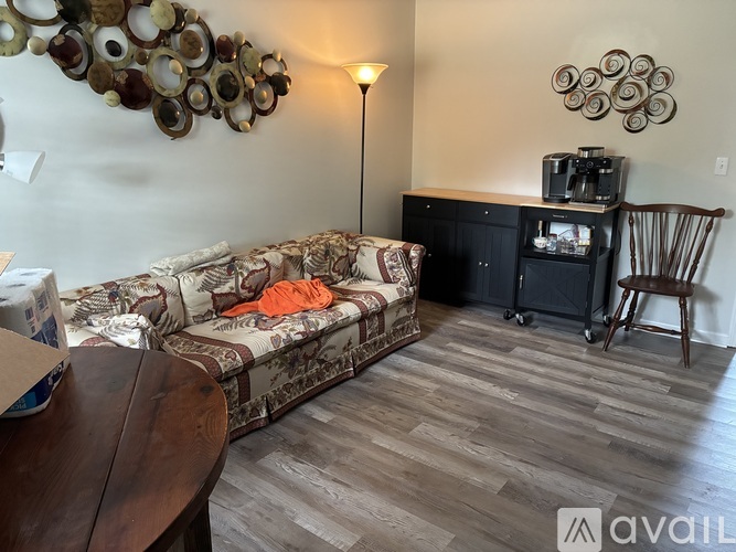 A living room with a couch, a chair, and a television.