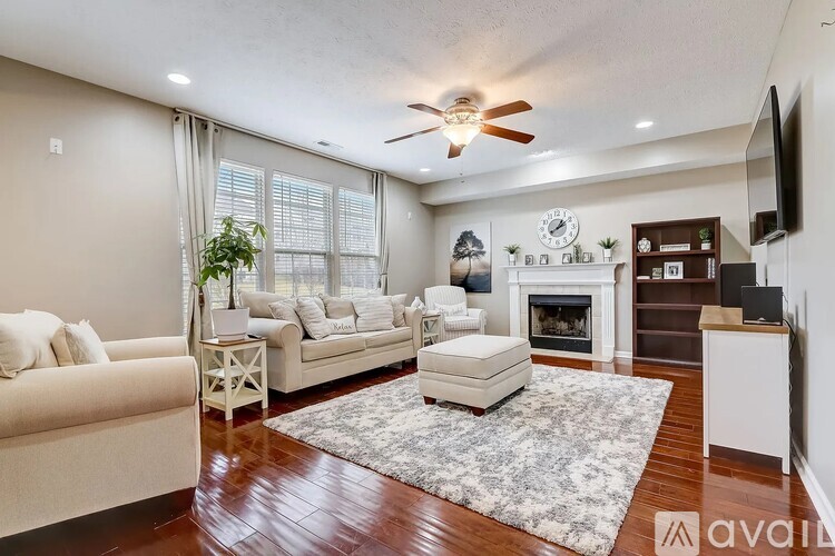 A living room with a fireplace and a television on the wall.