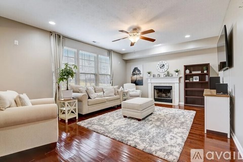 A living room with a fireplace and a television on the wall.