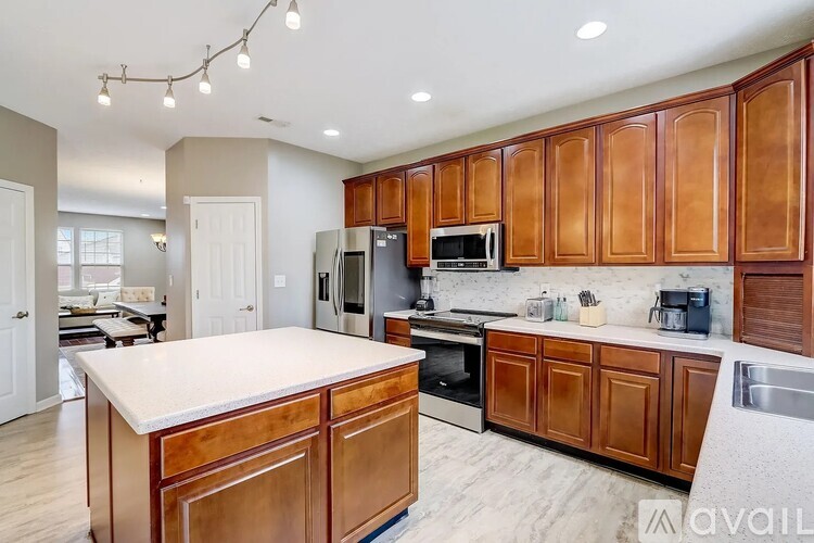 A kitchen with wooden cabinets and a white island.
