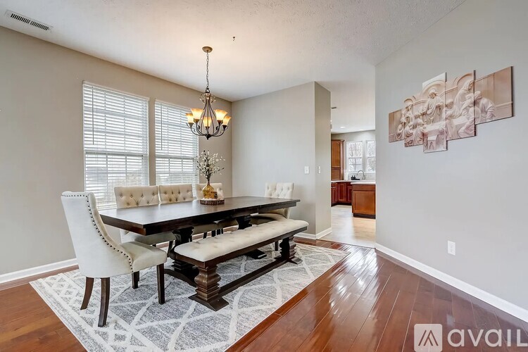 A dining room with a wooden table and chairs.