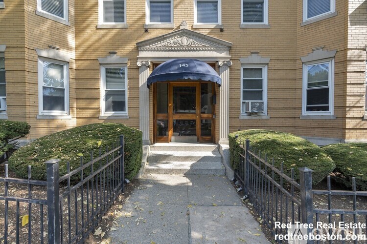A building with a blue awning and a sign that says "Red Tree Real Estate" is shown.