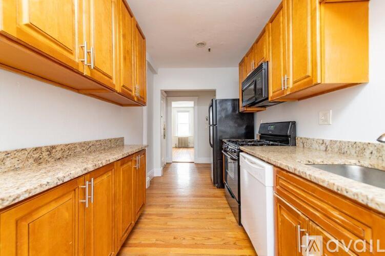 A kitchen with wooden cabinets and granite countertops.