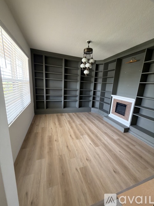 A room with wooden flooring and a fireplace.