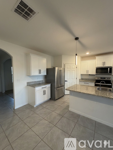 A kitchen with white cabinets and a granite countertop.