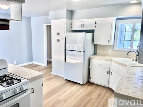 A kitchen with a white stove and cabinets.