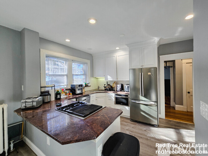 A kitchen with a brown counter top and stainless steel appliances.