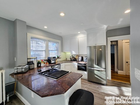 A kitchen with a brown counter top and stainless steel appliances.