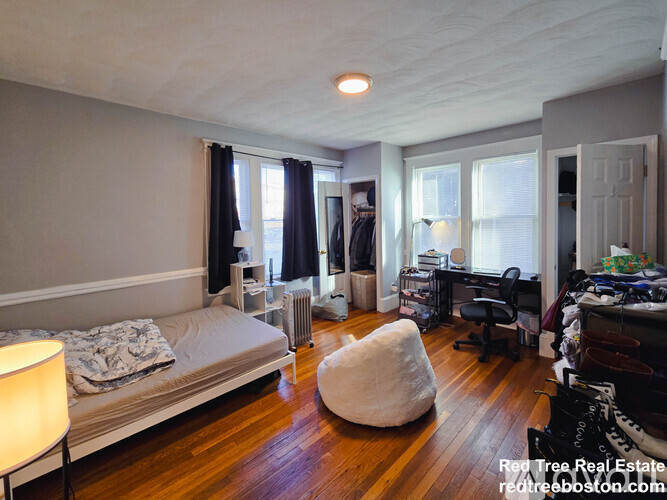 A bedroom with a bed, desk, and chair.