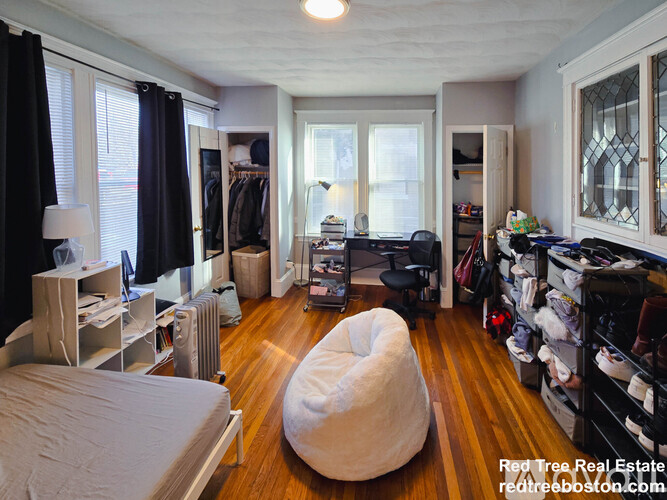 A room with a white bean bag chair in the middle of a wooden floor.