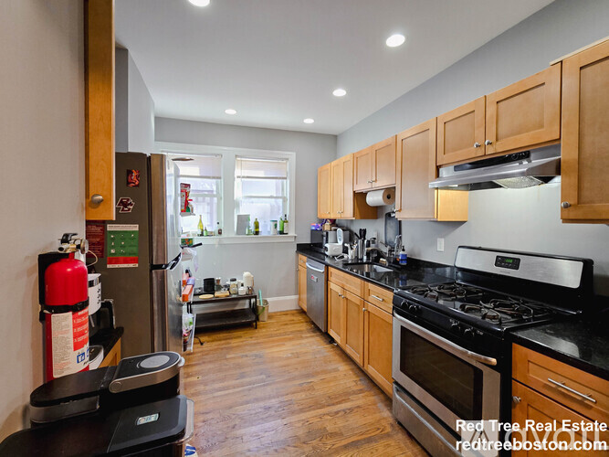 A kitchen with wooden cabinets and black countertops.
