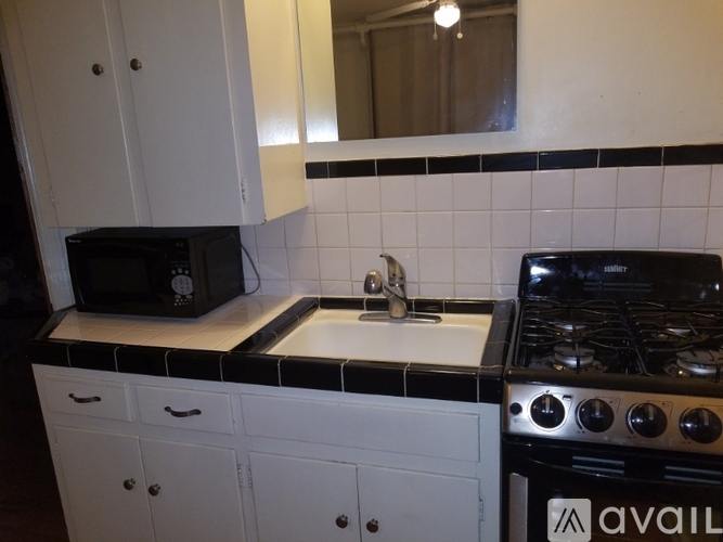 A black and white kitchen with a microwave, stove, and cabinets.